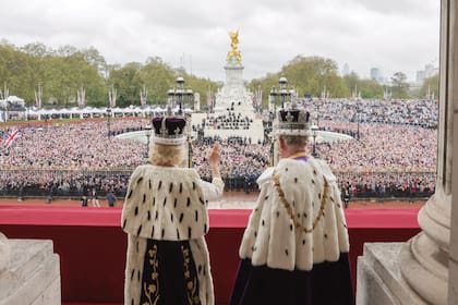 La multitud reunida frente a Buckingham recibe el saludo de Carlos III y Camilla.
