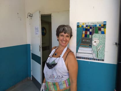 La muralista Karina Zinik, durante la instalación en el Hospital Penna de un mural homenaje al personal de salud a dos años de la pandemia de Covid