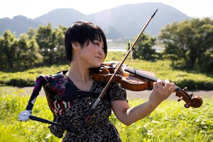 La música japonesa Manami Ito, que también es enfermera titulada y ex nadadora paralímpica, toca el violín con su brazo protésico durante una sesión de fotografía en Shizuoka.