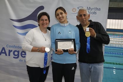 La nadadora Agostina Hein, en el Cenard, junto con sus padres, Ivana Pinkas y Enrique Hein