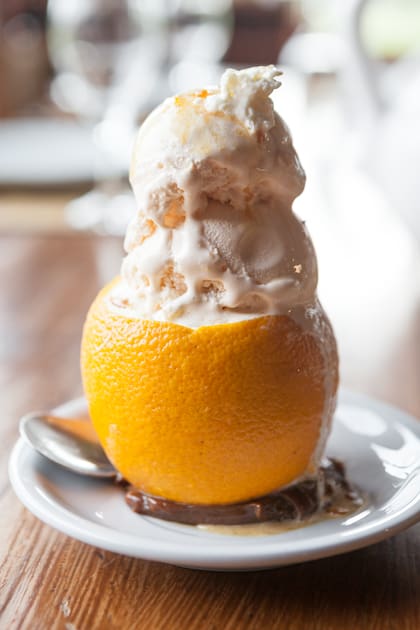 La naranja con helado de crema es uno de los postres recomendados del restaurante.