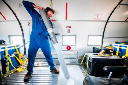 Joshua Willis, jefe de Oceans Melting Greenland, OMG, se prepara para lanzar una sonda cilíndrica de 1,5 metros a bordo del DC3