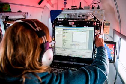 Ian Fenty, co-investigador de Oceans Melting Greenland, recibe señales de las sondas cilíndricas de 1,5 metros a bordo del avión