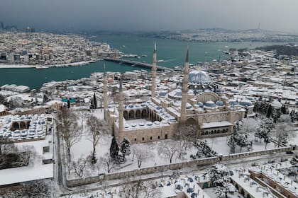 La nieve cubre las calles y la mezquita de Süleymaniye después de una fuerte nevada en Estambul, Turquía, el martes 25 de enero de 2022