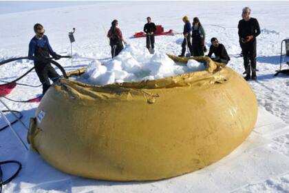 La nieve es colocada en un contenedor de caucho para después derretirla