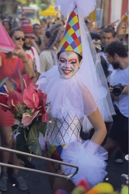 La novia, Alix Duvernoy, vestida como arlequín y rodeada por una banda callejera