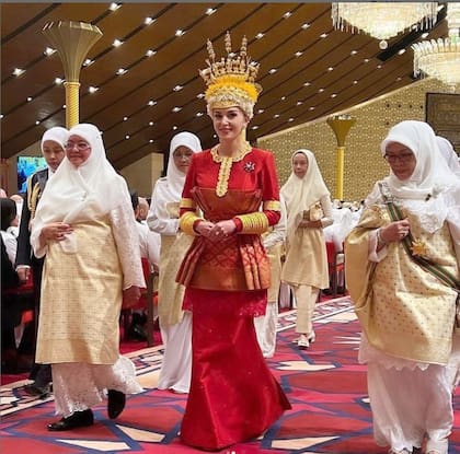 La novia, con la versión femenina del traje de su prometido, un diseño de silueta péplum e inspiración oriental repleto de bordados.
