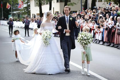 La novia llevó un vestido de encaje, tul y transparencias que acompañó con un velo de plumetí en cascada y la tiara Fringe de diamantes, estilo kokoshnik, una pieza histórica de la familia que es considerada uno de los símbolos del joyero real. Más allá de sus invitados, a la pareja los esperaba un grupo de mujeres ataviadas con los trajes típicos de Liechtenstein, con tocados negros