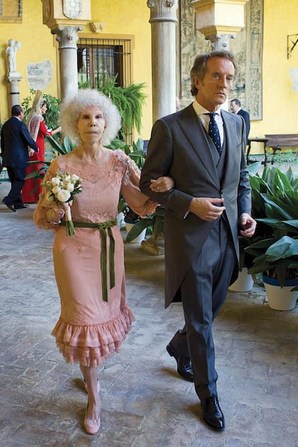 La novia lució un diseño de gasa y encaje color rosa, salpicado con el toque español y barroco de Victorio & Lucchino, que se ajustaba en la cintura con un lazo de terciopelo color verde. 
 