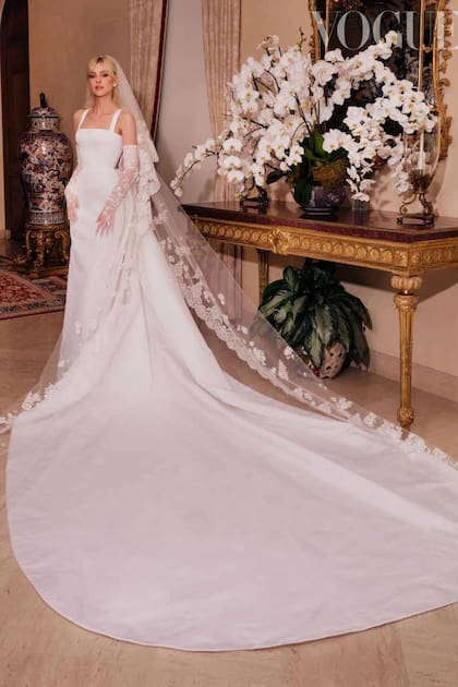 La novia lució un traje de Valentino con lazo en la espalda y gran
cola, que acompañó con guantes de encaje con adornos florales.
