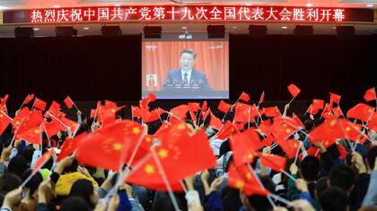 Los seguidores miran el discurso de Xi-Jinping en una pantalla gigante