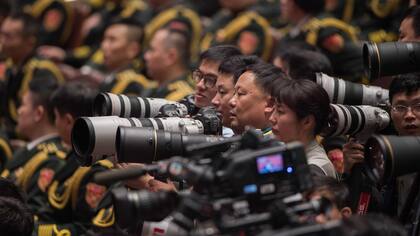 Fotógrafos y periodistas esperan el discurso del presidente Xi-Jinping