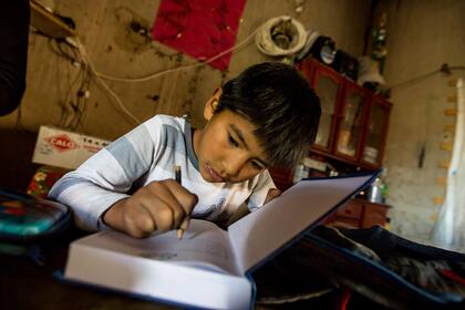 Ulises le pone su nombre al cuaderno de clase