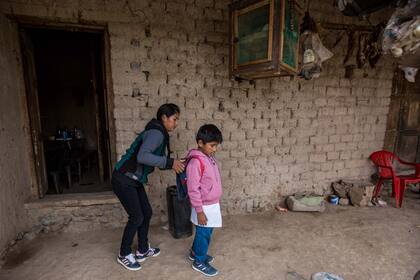 A las 8.40 su mamá le cuelga la mochila que lleva bordado su nombre