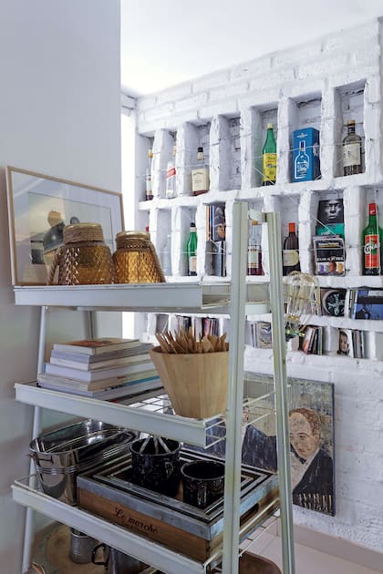 La pared de ladrillo se diagramó como una estantería a medida, con nichos para alojar el bar.