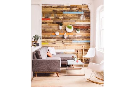 La pared de madera emana color y naturaleza en este living de techos altos