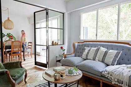 En el comedor, mesa clásica y sillas con respaldo esterillado. En el living, sillón francés de tres cuerpos (todo de La Rueda Antigüedades), otro heredado en verde, mesita ‘Rocha’ de álamo y hierro y alfombra de algodón (ambas de Lebon House).