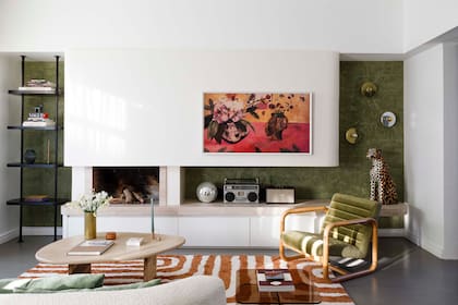 La pared en verde y detalles en color en los sillones y alfombra suman personalidad al living.