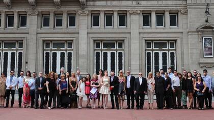 La pareja de Ingrid Allasia y Federico Carluccio (en el centro) con sus invitados, con el Teatro Colón como fondo