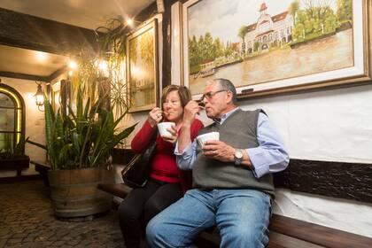 La pareja disfruta de un cuarto de helado. De fondo, una de las obras de Osvaldo inspiradas en Tigre.