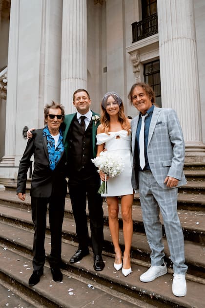 La pareja posa con sus famosos padres; a la izquierda, Ronnie Wood, guitarrista de los Rolling Stones y padre de Tyrone; y, a la derecha, Steve Harris, bajista de Iron Maiden y padre de Faye.