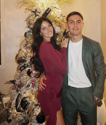 La pareja posando junto al árbol navideño