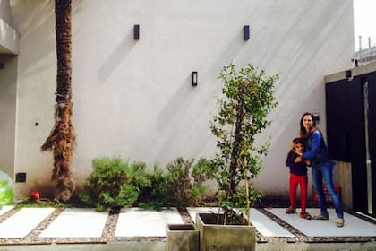 La parte frontal del jardín de esta casa con una pared desprovista de plantas.