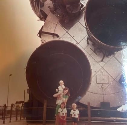 La pequeña Christina Koch al lado de lo que parece una nave espacial