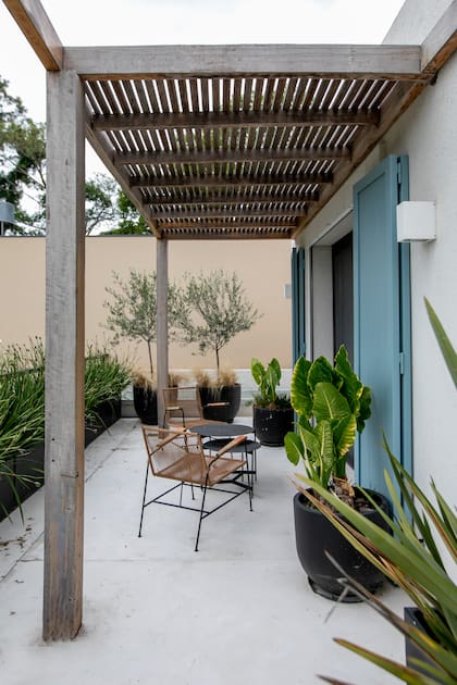 La pérgola cubre el patio, pero también funciona como parasol para el cuarto. Piso de cemento alisado.