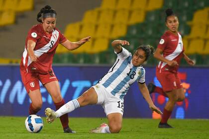 La peruana Ariana Muñoz intenta controlar el balón, pero Gabriela Chávez se arroja para impedirlo