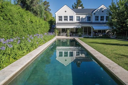 La pileta larga y angosta acompañada por Agapanthus africanus y cerco de caña ya existente. Se ven las líneas principales del jardín, que van perpendiculares al eje del espejo de agua, cuadrando el espacio.