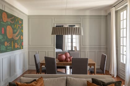 “La pintura de Milo Lockett del comedor, que los propietarios ya tenían, fue un punto de partida y lo primero que se colocó”, cuenta Cecilia. Sobre la mesa de comedor (Bahía Deco), elementos en papel maché (Mamá Elefanta). Sillas (Laura Bottinelli de Art Capitoné). Lámpara de techo (Weplight).