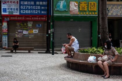 La poca gente que hay en el centro histórico de Macao guarda la distancia social para prevenir contagios de covid-19