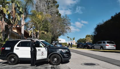 La policía acordona la calle en la que tres personas murieron y cuatro más resultaron heridas en un tiroteo en una casa en un exclusivo vecindario de Los Ángeles, el sábado 28 de enero pasado.