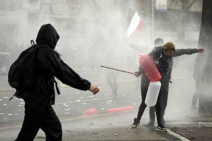 La policía antidisturbios rocía con cañones de agua a los manifestantes durante una marcha para conmemorar el 50º aniversario del golpe militar dirigido por el general Augusto Pinochet (1915-2006) contra el presidente socialista Salvador Allende en Santiago el 10 de septiembre de 2023.