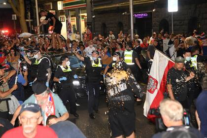 La policía arroja gas pimienta para despejar el camino del automóvil que traslada a Novak Djokovic