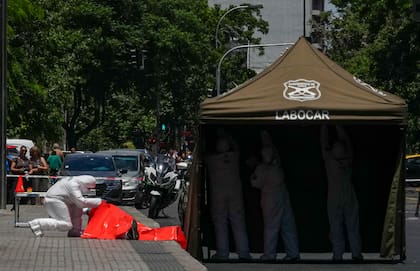 La policía de operaciones especiales trabaja en el lugar en el que se encontró un cadáver en plena calle, mientras arman una carpa para cubrir el cuerpo en el centro de Santiago, Chile, el 18 de noviembre de 2024.