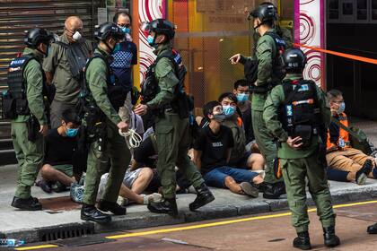 La policía detiene a personas mientras patrullan el área después de que los manifestantes convocaron una pprotesta en Hong Kong el 6 de septiembre de 2020 contra la decisión del gobierno de posponer la elección del consejo legislativo debido al coronavirus y la ley de seguridad nacional