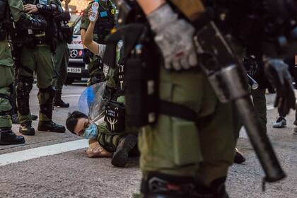 La policía detiene a un hombre mientras patrulla el área en medio de una protesta en Hong Kong el 6 de septiembre de 2020 contra la decisión del gobierno de posponer las elecciones del consejo legislativo