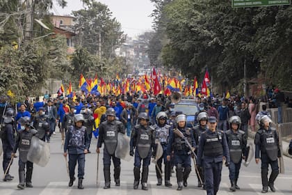 La policía escolta a partidarios del Partido Rastriya Prajatantra, o partido democrático nacional, durante una protesta a favor de la monarquía en Katmandú, Nepal, el 21 de febrero de 2024.