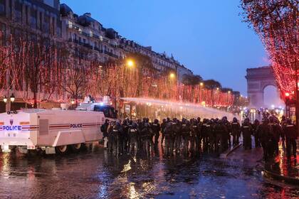 La policía lanza gas lacrimógeno a los manifestantes frente al Arco del Triunfo