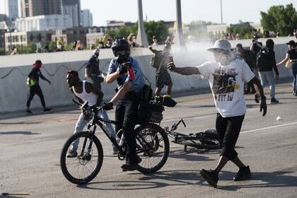 La policía llega y usa gas pimienta después de que un hombre condujera un camión cisterna hacia una protesta pacífica en el puente I-35W sobre el río Mississippi el 31 de mayo de 2020 en Minneapolis, Minnesota