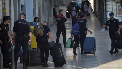 La policía nacional abandona el hotel y pasa frente a los Mossos, la fuerza regional catalana