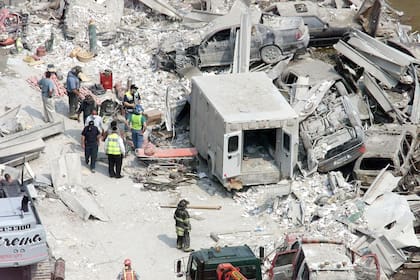 La policía y el personal del departamento de bomberos junto a una ambulancia y otros vehículos que fueron destruidos en el World Trade Center