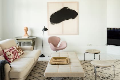 La poltrona/mesa y los taburetes sobre la alfombra marroquí son de Poul Kjærholm (1929-1980). La altura de los primeros reflejan una de las máximas del Japandi: incluir muebles bajos en los ambientes.