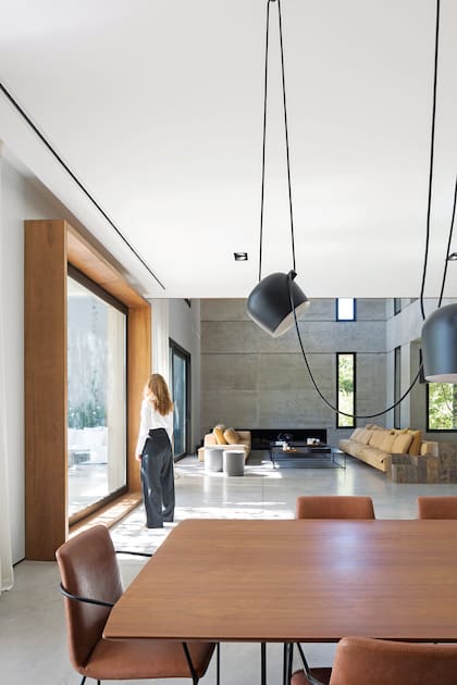 La presencia de la arquitecta Kreth junto a la ventana da cuenta tanto de su altura como de la importancia de su reborde en madera. Mesa (Estudio Karina Kreth) y sillas ‘Horqueta’ (Federico Churba).