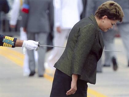 La presidenta de Brasil, Dilma Rousseff, parece ser traspasada por una espada que empuña un militar cuando éste le rinde honores
