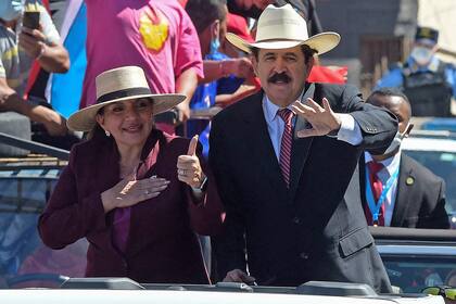 La presidenta electa de Honduras, Xiomara Castro, levanta el pulgar mientras su esposo, el expresidente hondureño (2006-2009), Manuel Zelaya, saluda mientras son conducidos por el bulevar Suyapa hacia el Estadio Nacional, donde se llevará a cabo la ceremonia de toma de posesión
