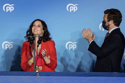La presidenta regional de Madrid, Isabel Díaz Ayuso, a la izquierda, y el líder del conservador Partido Popular, Pablo Casado, a la derecha, celebran los resultados de las elecciones regionales ante la sede del partido en Madrid, España, el martes 4 de mayo de 2021. (AP Fhoto/Bernat Armangue)
