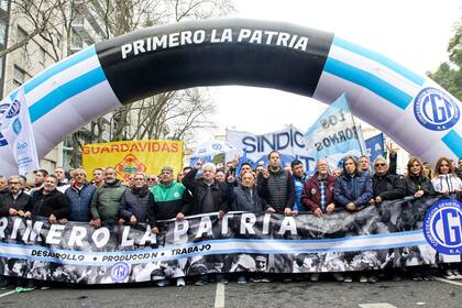 La primera línea de la CGT: Héctor Daer, Carlos Acuña, Pablo Moyano, Julio Piumato, Raúl Durdos, Pablo Flores, Cristian Jerónimo, Omar Plaini y Daniel Ricci sostienen la bandera con la leyenda "Primero la patria"